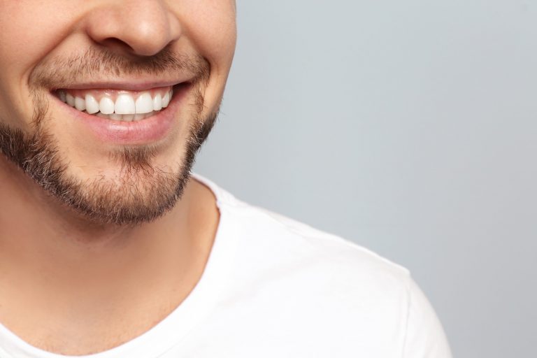 Man with straight teeth after using ClearCorrect aligners shows off his smile