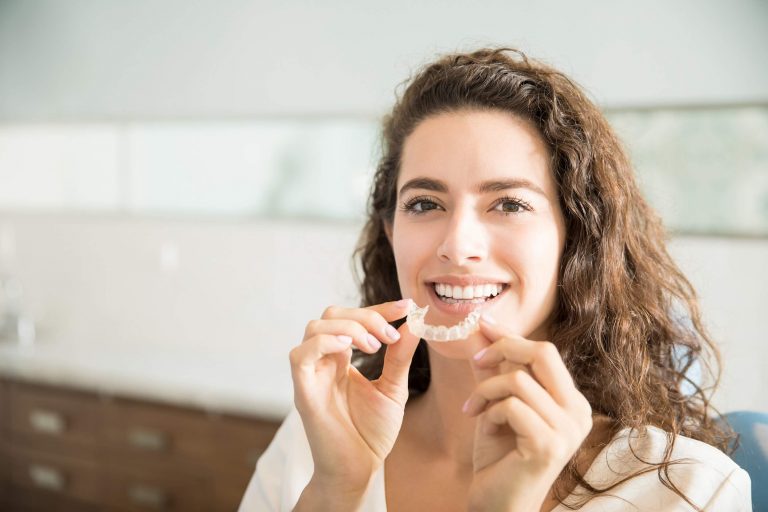 Woman at dentist receives custom clear teeth aligner