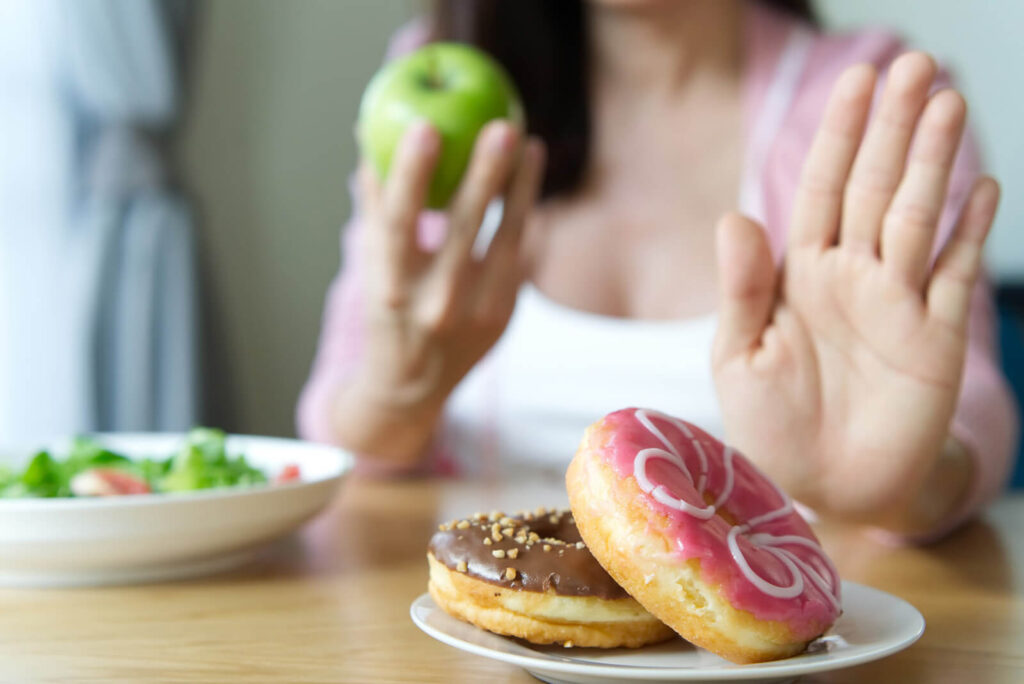 a girl saying yes to fresh food and say no to sugary food
