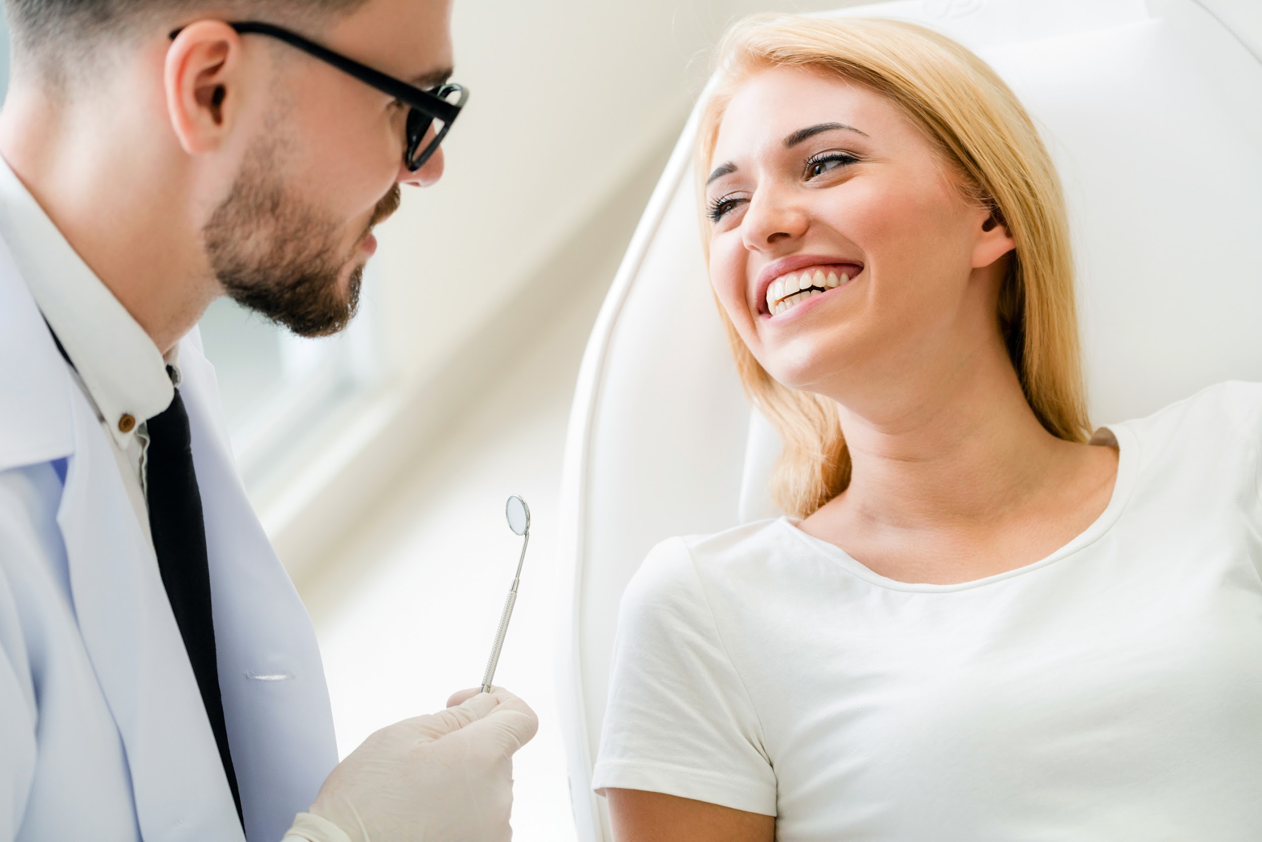 a happy patient is talking to the dentist