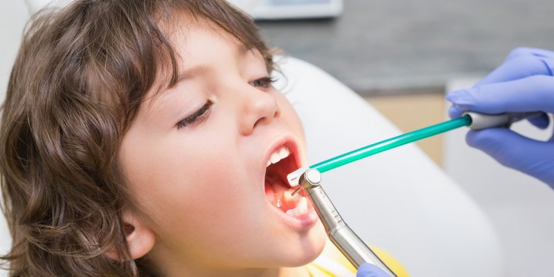 a dentist is treating the tooth decay of the child